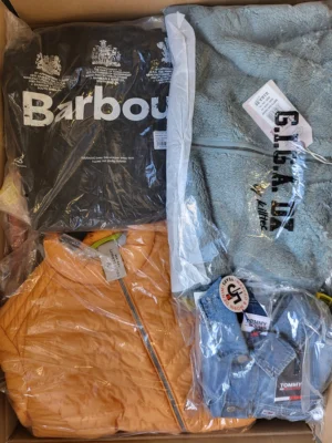 The photo shows a package with clothing in the category AJS.