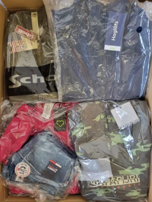 The photo shows a package with clothing in the category AJS.