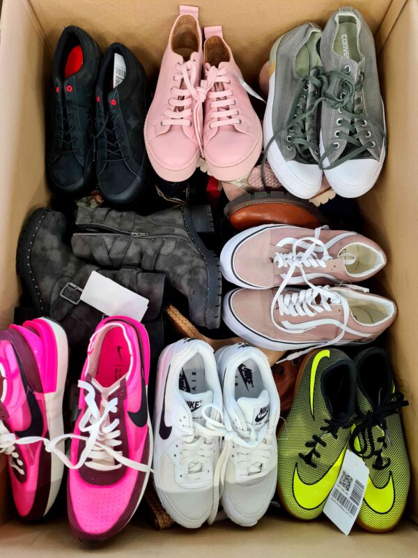 The photo shows a package with footwear in the category SH.