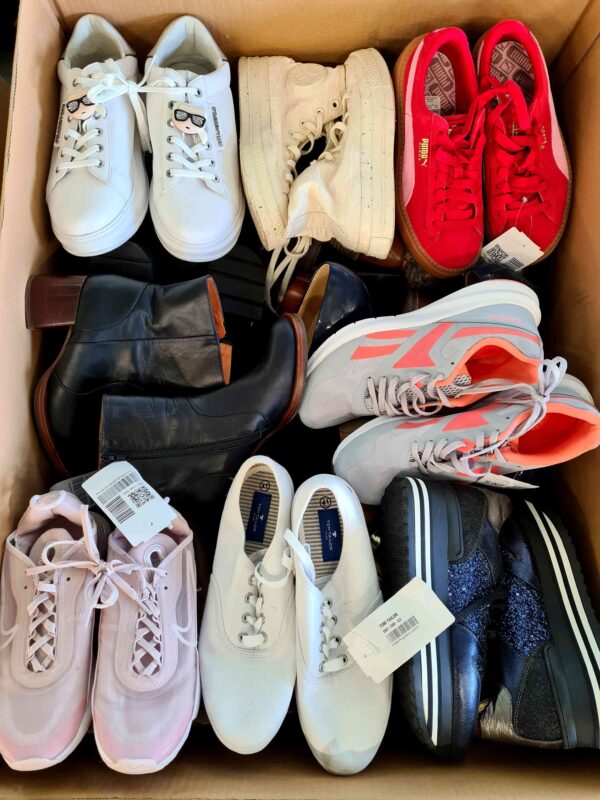 The photo shows a package with footwear in the category SH.