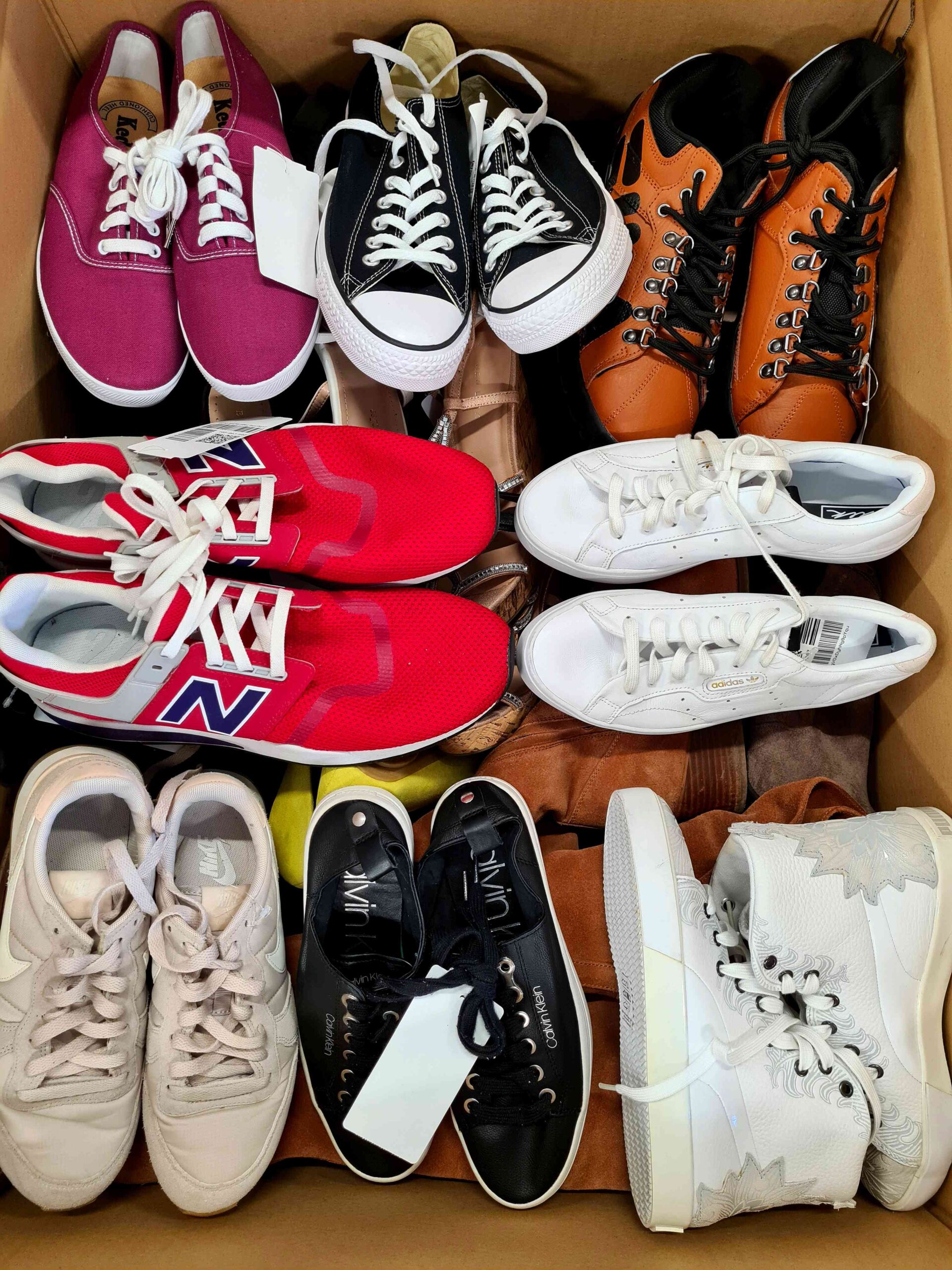 The photo shows a package with footwear in the category SH.