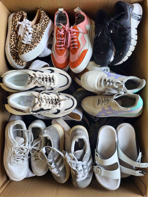 The photo shows a package with footwear in the category SH.