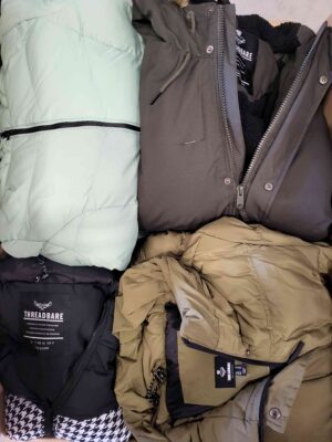 The photo shows a package with clothing in the category TJ.