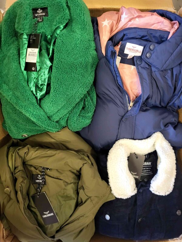 The photo shows a package with clothing in the category TJ.