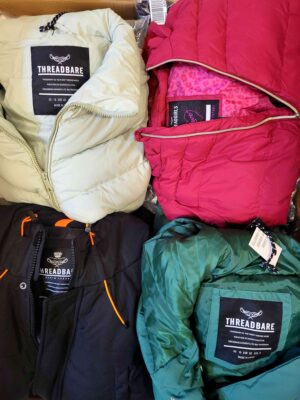 The photo shows a package with clothing in the category TJ.