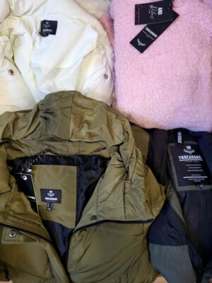 The photo shows a package with clothing in the category TJ.