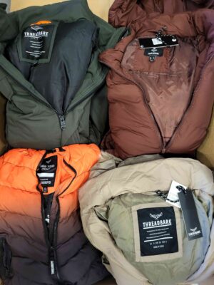 The photo shows a package with clothing in the category TJ.