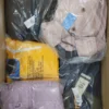 The photo shows a package with clothing in the category AJS.