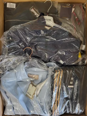 The photo shows a package with clothing in the category AJS.