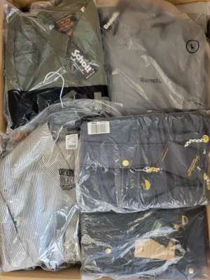 The photo shows a package with clothing in the category AJS.