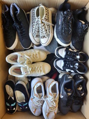 The photo shows a package with footwear in the category SH.