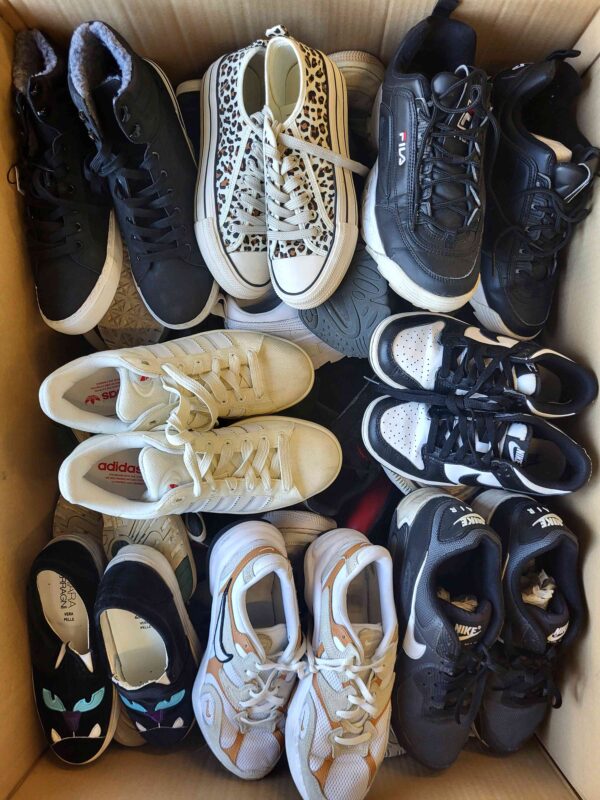 The photo shows a package with footwear in the category SH.