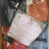 The photo shows a package with clothing in the category AJS.