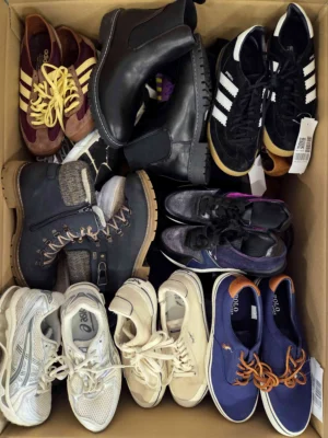 The photo shows a package with footwear in the category SH.