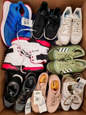 The photo shows a package with footwear in the category SH.