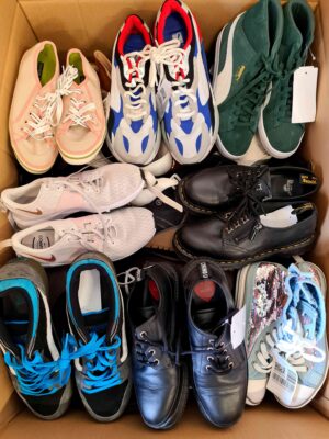 The photo shows a package with footwear in the category SH.