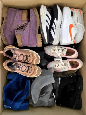 The photo shows a package with footwear in the category SH.