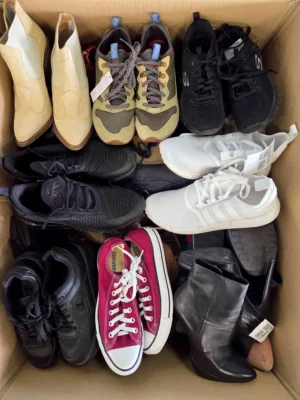 The photo shows a package with footwear in the category SH.