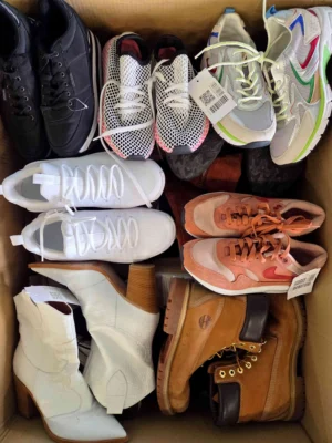 The photo shows a package with footwear in the category SH.