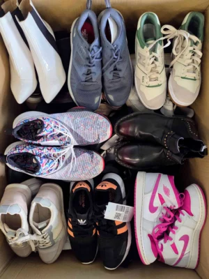 The photo shows a package with footwear in the category SH.