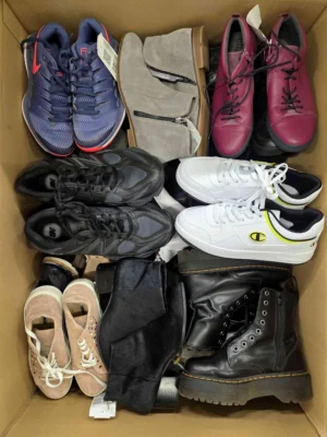 The photo shows a package with footwear in the category SH.