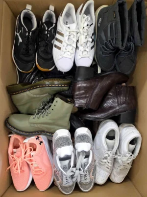 The photo shows a package with footwear in the category SH.