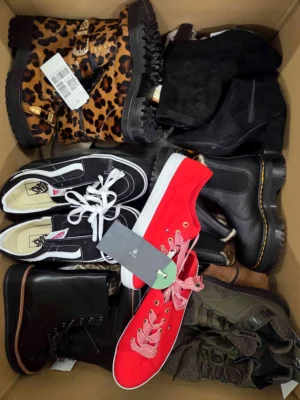 The photo shows a package with footwear in the category SH.