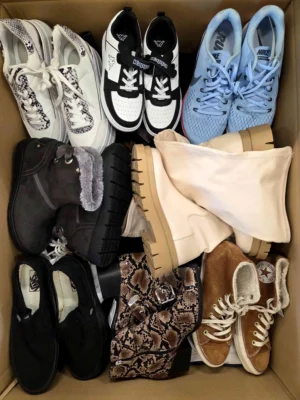 The photo shows a package with footwear in the category SH.
