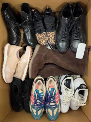 The photo shows a package with footwear in the category SH.
