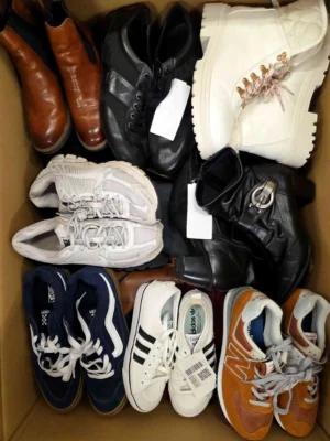 The photo shows a package with footwear in the category SH.