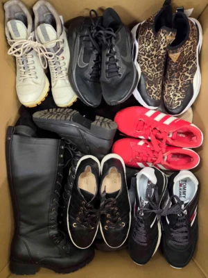 The photo shows a package with footwear in the category SH.