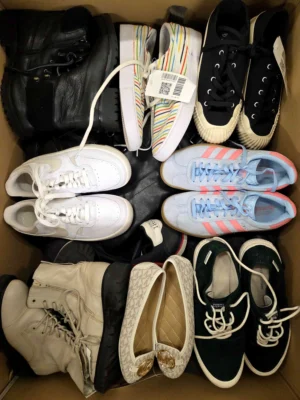 The photo shows a package with footwear in the category SH.