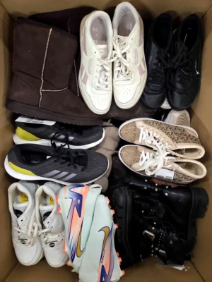 The photo shows a package with footwear in the category SH.