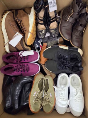 The photo shows a package with footwear in the category SH.