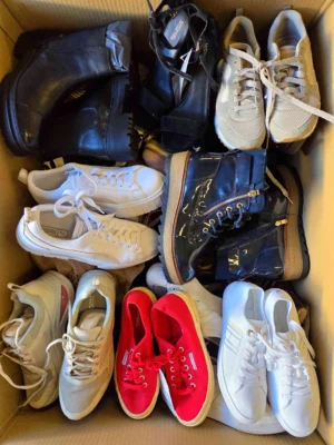 The photo shows a package with footwear in the category SH.