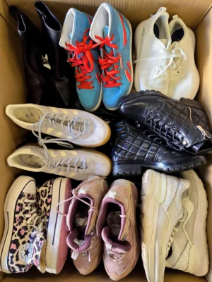 The photo shows a package with footwear in the category SH.