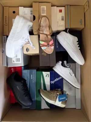 The photo shows a package with footwear in the category AS.