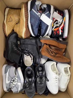 The photo shows a package with footwear in the category SH.
