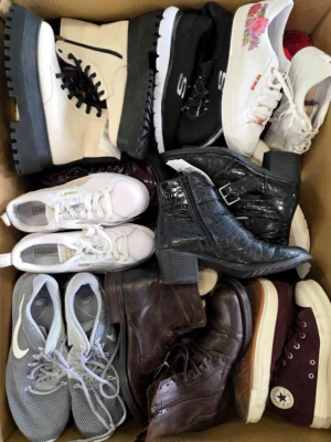 The photo shows a package with footwear in the category SH.
