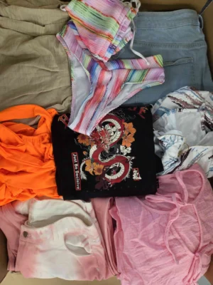 The photo shows a package with clothing in the category SN.