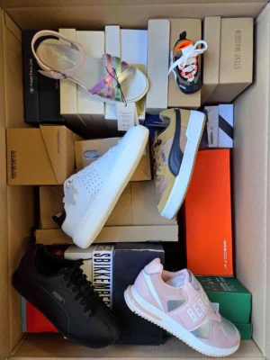 The photo shows a package with footwear in the category AS.