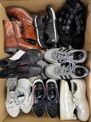 The photo shows a package with footwear in the category SH.