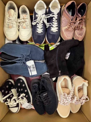 The photo shows a package with footwear in the category SH.