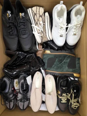 The photo shows a package with footwear in the category SH.