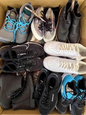The photo shows a package with footwear in the category SH.