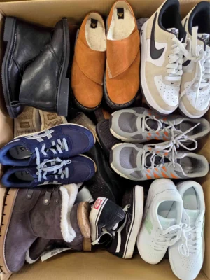 The photo shows a package with footwear in the category SH.