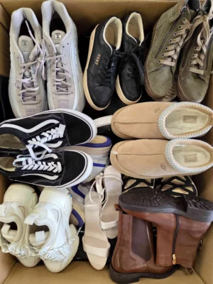 The photo shows a package with footwear in the category SH.