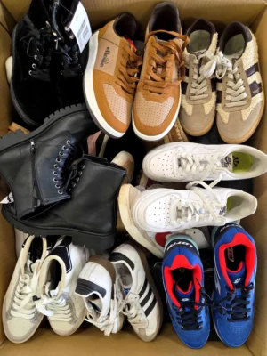 The photo shows a package with footwear in the category SH.