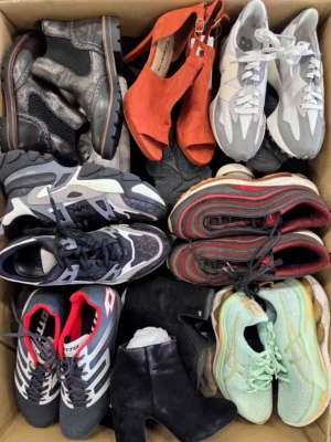 The photo shows a package with footwear in the category SH.