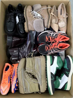 The photo shows a package with footwear in the category SH.